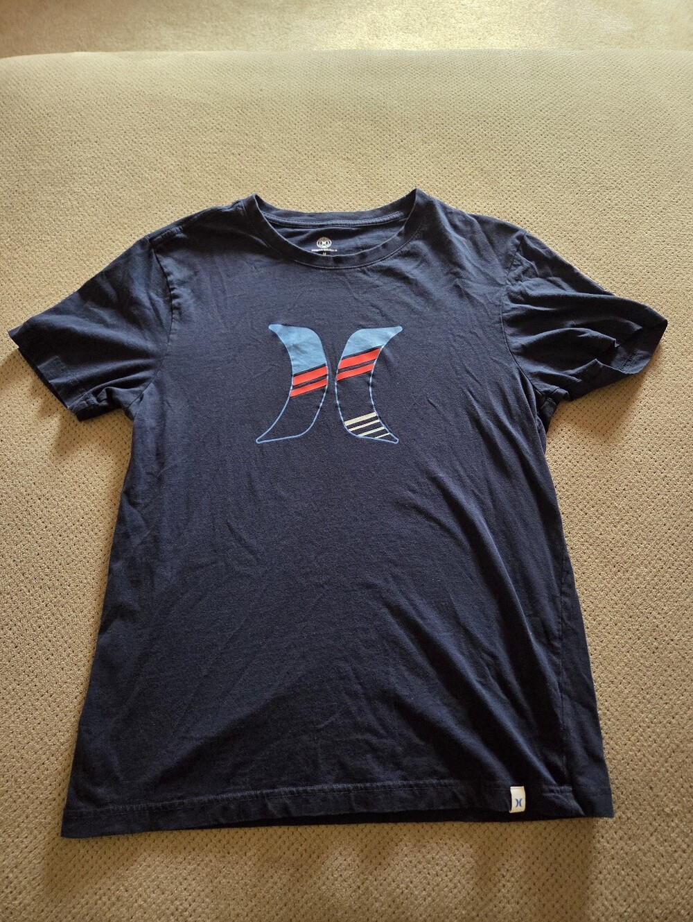 navy blue Hurley short-sleeve t-shirt featuring a stylized, striped "H" logo